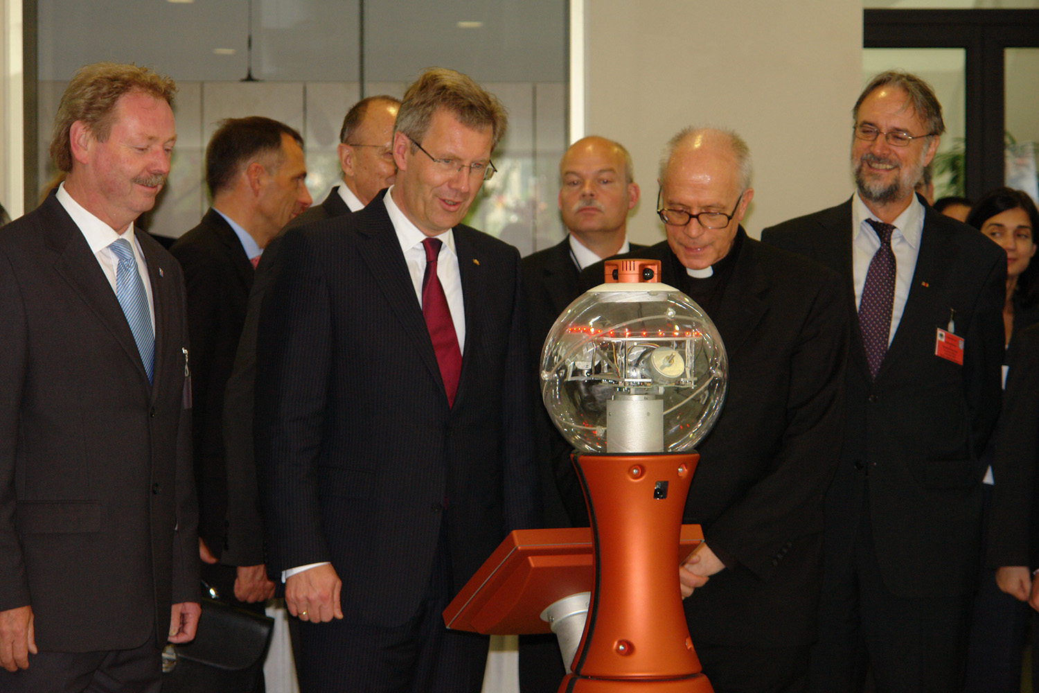 Federal President Wulff and other guests are welcomed to the IDMT by a robot.