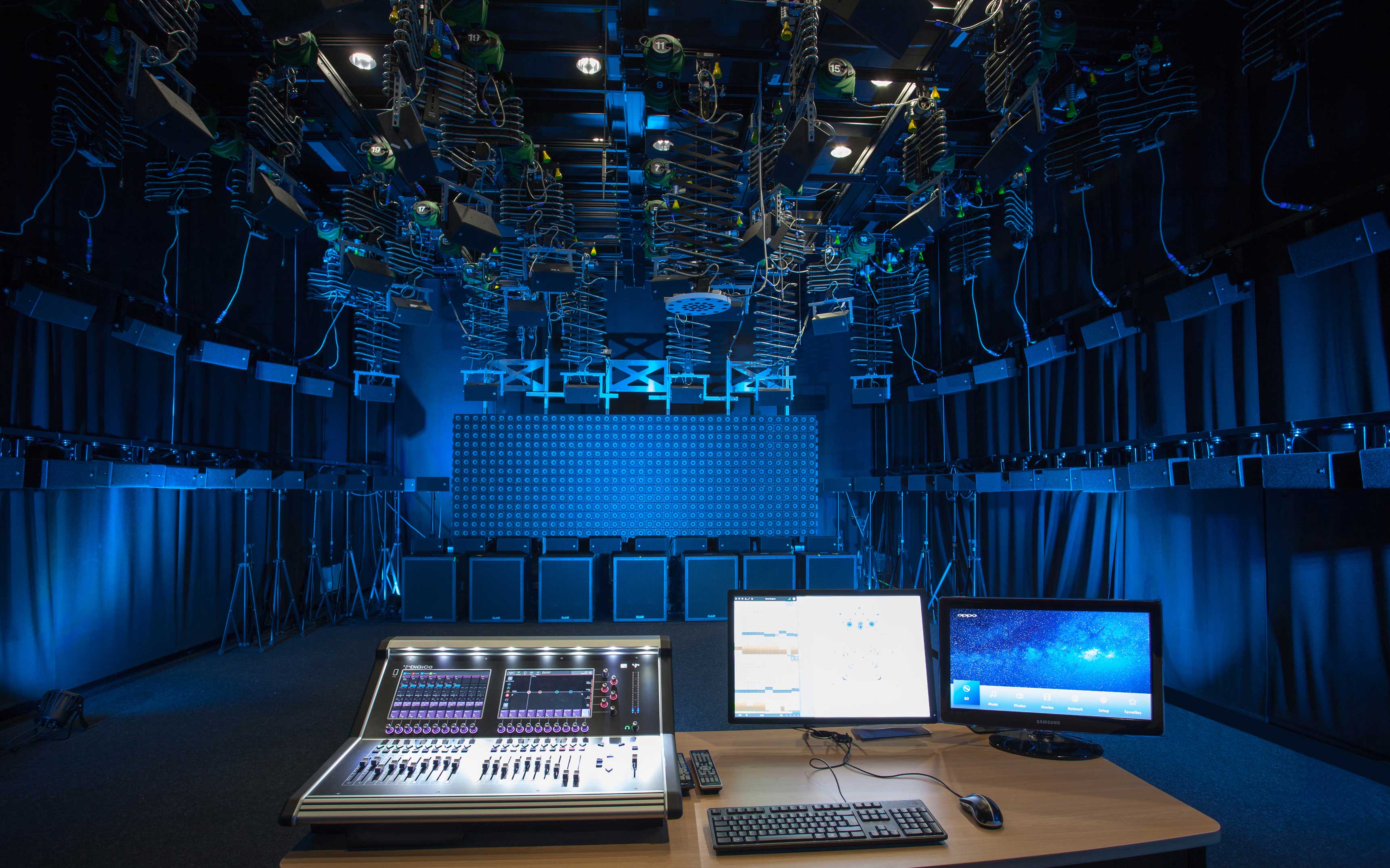 Raum mit vielen Lautsprechern und Mischpult und Monitore im Vordergrund